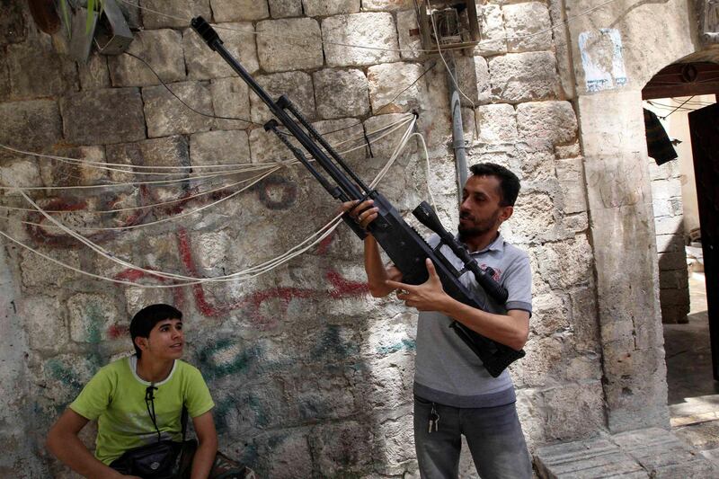 A Free Syrian Army fighter inspects his weapon in Aleppo's Karm al-Jabal district, June 2, 2013. REUTERS/Muzaffar Salman SYRIA (SYRIA - Tags: CIVIL UNREST) *** Local Caption ***  SYR10_SYRIA-CRISIS-_0602_11.JPG