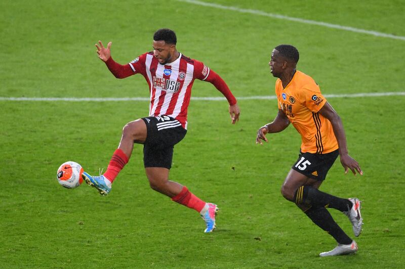 Sheffield United's French striker Lys Mousset, left, runs with the ball next to Wolverhampton Wanderers' Willy Boly on Wednesday. AFP
