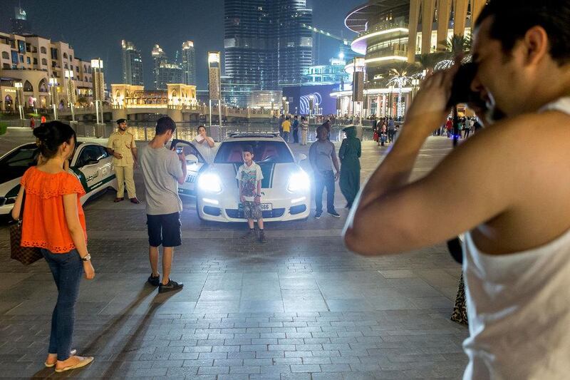 People have their photo taken with the Porche Panamera S E-Hybrid in Downtown Dubai.