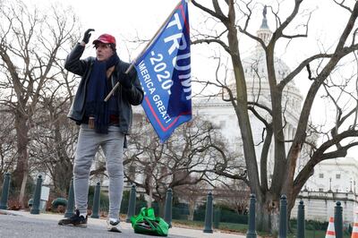 WASHINGTON, DC - JANUARY 07: A lone Trump supporter holds a flag outside the U.S. Capitol January 7, 2021 in Washington, DC. The U.S. Congress has finished the certification for President-elect Joe Biden and Vice President-elect Kamala Harris’ electoral college win after pro-Trump mobs stormed the Capitol and temporarily stopped the process.   Alex Wong/Getty Images/AFP
== FOR NEWSPAPERS, INTERNET, TELCOS & TELEVISION USE ONLY ==
