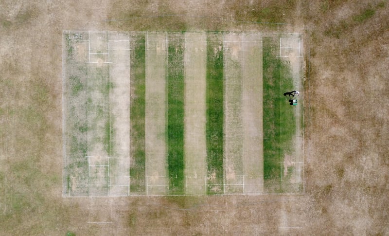 A groundsman at Boughton and Eastwell Cricket Club in Ashford, Kent, prepares the wickets for matches. PA