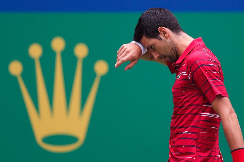 Novak Djokovic of Serbia wipes his sweat as he plays against Stefanos Tsitsipas of Greece during the men's singles quarterfinals match at the Shanghai Masters tennis tournament at Qizhong Forest Sports City Tennis Center in Shanghai, China, Friday, Oct. 11, 2019. (AP Photo/Andy Wong)