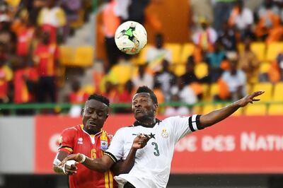 (FILES) In this file photo taken on January 17, 2017 Ghana's forward Asamoah Gyan (R) heads the ball with Uganda's midfielder Tony Mawejje during the 2017 Africa Cup of Nations group D football match between Ghana and Uganda in Port-Gentil. Asamoah Gyan was included in Ghana's squad for the Africa Cup Nations on June 10, 2019 after reverting his decision to retire from international duty having lost the captaincy. / AFP / Justin TALLIS
