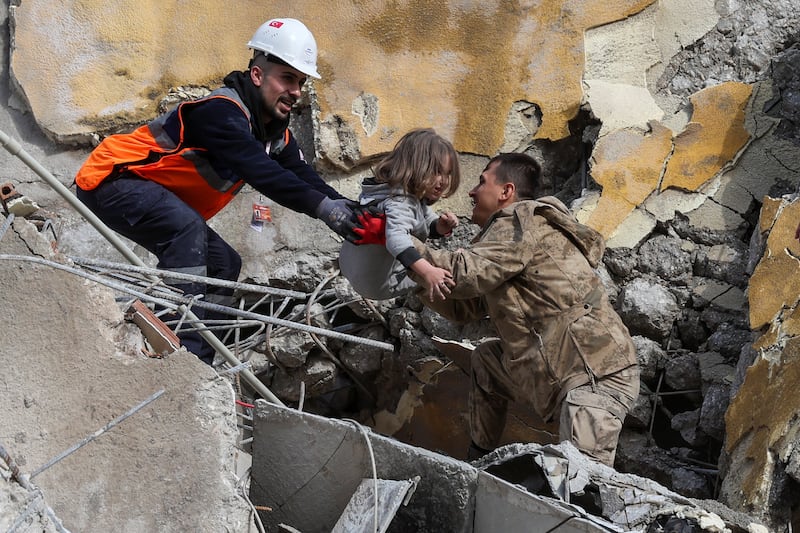 Muhammet Ruzgar, five, is carried by rescuers from the site of a damaged building in Hatay. Reuters