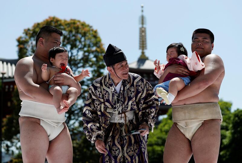 Babies, Kizuki and Sarah, cry as they are held up by amateur sumo wrestlers during a baby crying contest at Sensoji temple in Tokyo, Japan. In the contest two wrestlers each hold a baby while a referee makes faces and loud noises to make them cry. The baby who cries the loudest wins. The ritual is believed to aid the healthy growth of the children and ward off evil spirits. Issei Kato / Reuters