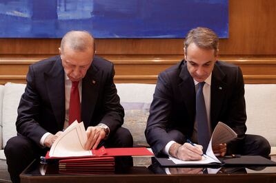 Greek Prime Minister Kyriakos Mitsotakis, right, and Turkish President Tayyip Erdogan sign a joint declaration in Athens on December 7. They have agreed to co-operate on security around the Aegean islands, where thousands of migrants have died. Reuters
