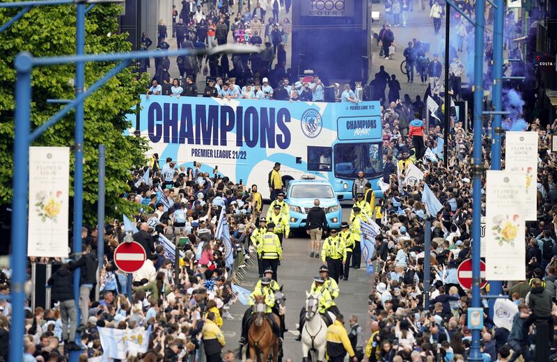 Fans line the streets of Manchester for the open-top bus parade. PA