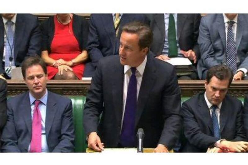 Britain's Prime Minister David Cameron, flanked by Deputy Prime Minister Nick Clegg, left, and Finance Minister George Osborne, speaks during an emergency session of Parliament on Thursday  about the rioting in British cities.