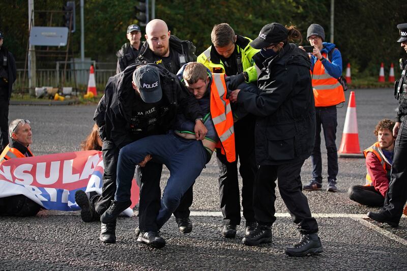 Protesters from Insulate Britain are removed by police after they blocked a road near the Holiday Inn Express Motorway Airport in Manchester. All photos: PA