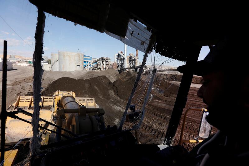 A worker drives a bulldozer, transporting a treated phosphate to be put in wagons, at a phosphate production plant in Metlaoui, Tunisia.  Reuters