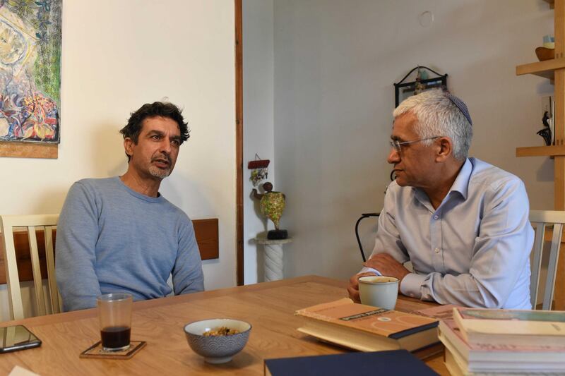 Moshe Shitrit (L) sits at home in Tel Aviv with his brother, Itzhak Shitrit, beside books about Morocco. Rosie Scammell for the National
