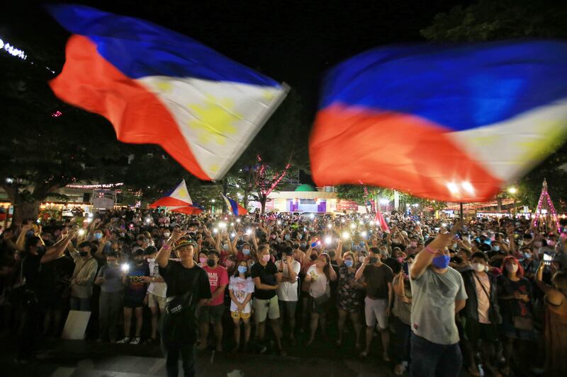 Supporters of presidential candidate and Vice President of the Philippines Leni Robredo take a part in a prayer vigil after the final result of votes in Manila. AFP