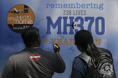 Visitors write messages at a commemoration event to mark the fifth anniversary of the flight's disappearance. Getty Images