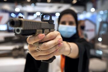 A visitor tries out a semi-automatic 9mm. ZEV Technologies custom GLOCK at Idex 2021 that wraps on February 25. Victor Besa / The National. 