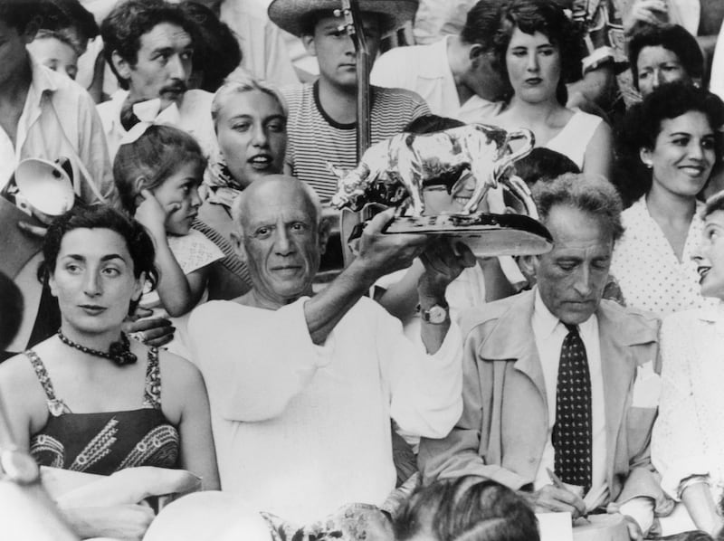 Picasso holds up a statuette of a fighting bull, presented to him by toreadors in appreciation of his art, in the stands at a bullfight at Vallauris, France, August 1955. Getty Images