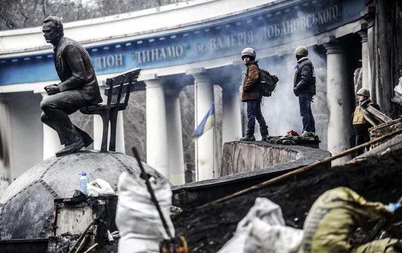 Anti-government protesters stand on a barricade at the entrance of Kiev’s Independence square on February 23, 2014. The Ukraine parliament gave itself three days to form a new government after impeaching president Viktor Yanukovich and calling early elections after a week of carnage. Bulent Kilic / AFP photo