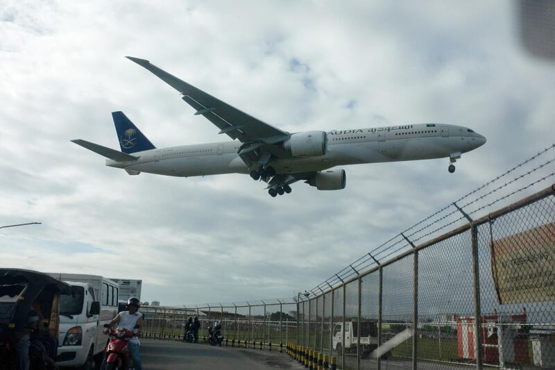 A Saudi Arabian Airlines aircraft prepares to land at Ninoy Aquino International Airport (NAIA) in Manila, the Philippines, on Thursday, Feb. 13, 2020. In response to the coronavirus outbreak, the Philippine government has banned travel to Hong Kong, along with Macau and mainland China. Earlier this month, the Philippines' Labor Department announced that it would offer financial assistance and temporary housing to workers who'd gotten stranded in the capital en route to their jobs overseas. Photographer: Geric Cruz/Bloomberg