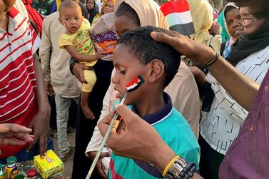 A boy gets the Sudanese flag painted on his cheek at the sit-in protest outside the army headquarters in Khartoum. Hamza Hendawi for The National