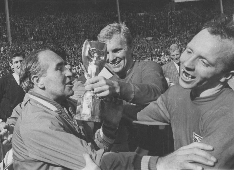 England midfield player Nobby Stiles, right, looks at the Jules Rimet Cup, held by England captain Bobby Moore. AP