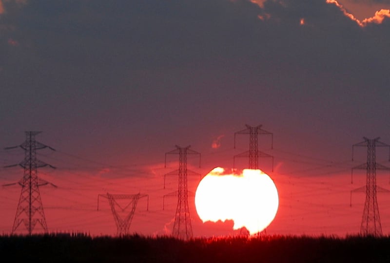 The Sun sets behind high-voltage power lines and electricity pylons at a highway northeast of Cairo, Egypt, September 15, 2018. REUTERS/Amr Abdallah Dalsh