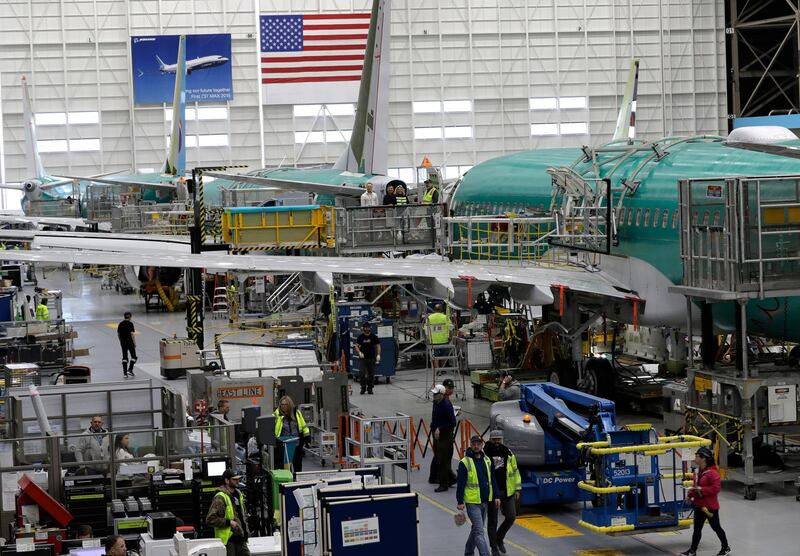 FILE - In this March 27, 2019, file photo people work on the Boeing 737 MAX 8 assembly line during a brief media tour in Boeing's 737 assembly facility in Renton, Wash. On Friday, Jan 3, 2020, the Institute for Supply Management, an association of purchasing managers, reports on activity by U.S. manufacturers in December.  (AP Photo/Ted S. Warren, File)