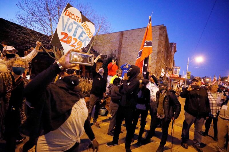 Demonstrators marching for voting rights pass supporters of US President Donald Trump carrying Confederate flags in Graham, North Carolina, US. Reuters