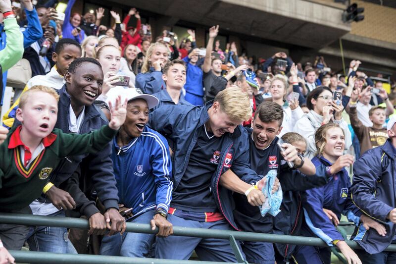 Fans of retired Jamaican Olympic and World champion sprinter Usain Bolt, wrestle for a T-Shirt thrown by Usain Bolt, during a PUMA School of Speed Athletic event at the Ruimsig Stadium in Roodepoort, Johannesburg, on January 29, 2018. / AFP PHOTO / WIKUS DE WET