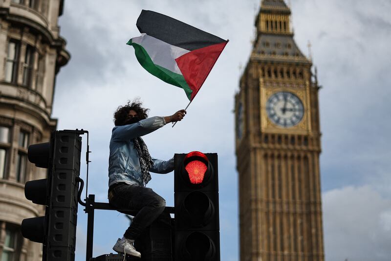 A protester waves a Palestinian flag in London's Parliament Square on Saturday. The UK capital has been the scene of several major pro-Palestinian rallies in this latest round of the conflict. AFP