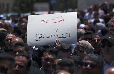 A demonstrator lifts a placard in Arabic which reads 'Yes to an independent judiciary' during a rally by Palestinian lawyers in front of the prime minister's office in Ramallah. AFP