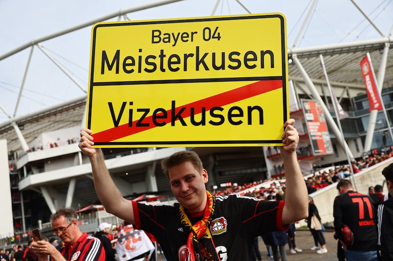 A Bayer Leverkusen fan holds up a sign outside the stadium. Reuters 