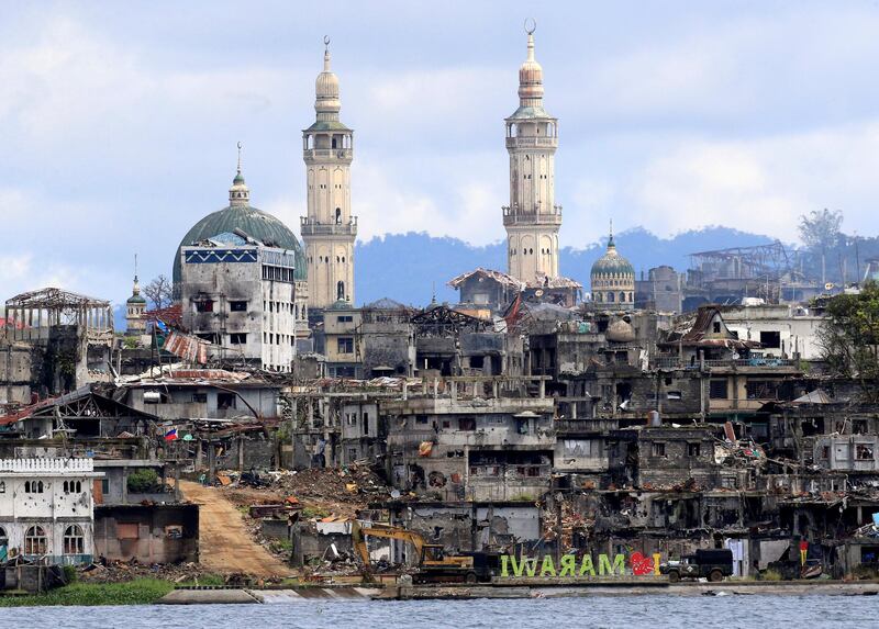 A signage of "I love Marawi" is seen in front of damaged houses, buildings and a mosque inside a war-torn Marawi city, southern Philippines October 26, 2017, after the Philippines on Monday announced the end of five months of military operations in a southern city held by pro-Islamic State rebels. REUTERS/Romeo Ranoco     TPX IMAGES OF THE DAY
