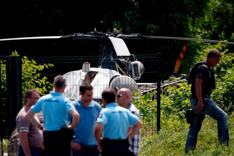 TOPSHOT - This picture taken on July 1, 2018 in Gonesse, north of Paris shows police near a French helicopter Alouette II abandoned by French armed robber Redoine Faid after his escape from prison in Reau. / AFP / GEOFFROY VAN DER HASSELT
