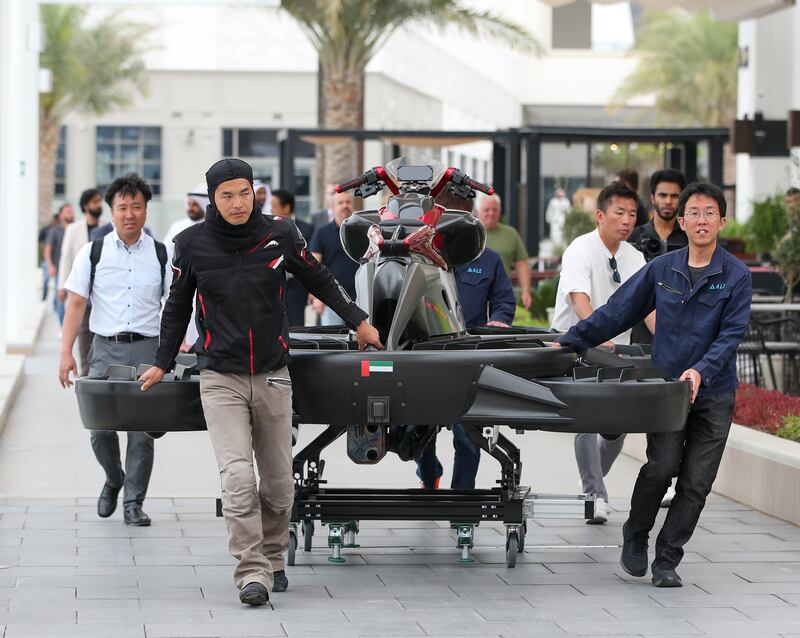 A Japanese team of engineers and a pilot arrive at the hover bike demonstration 