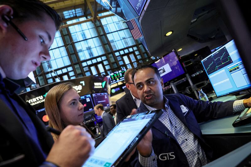 Traders at the New York Stock Exchange. Weakening prices, in particular, are driving the synchronised gains across assets, experts say. Reuters