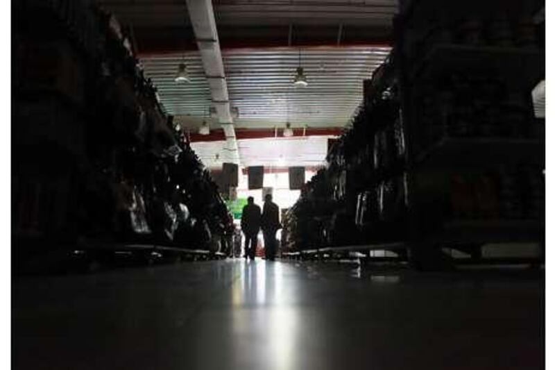 Supermarket customers shop in the dark during one of Sharjah's frequent power cuts.