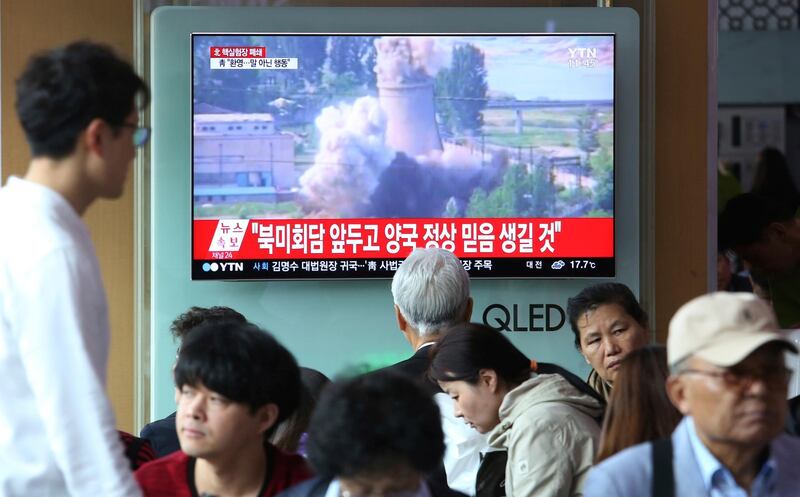 A TV screen shows file footage of the demolition of the 60-foot-tall cooling tower at its main reactor complex in Yongbyon, North Korea, on June 27, 2008 during a news program at the Seoul Railway Station in Seoul, South Korea, Sunday, May 13, 2018. North Korea said Saturday that it will dismantle its nuclear test site in less than two weeks, in a dramatic event that would set up leader Kim Jong Un's summit with President Donald Trump next month. Trump welcomed the "gracious gesture." The signs read: "Leaders of the United State and North Korea should have belief." (AP Photo/Ahn Young-joon)
