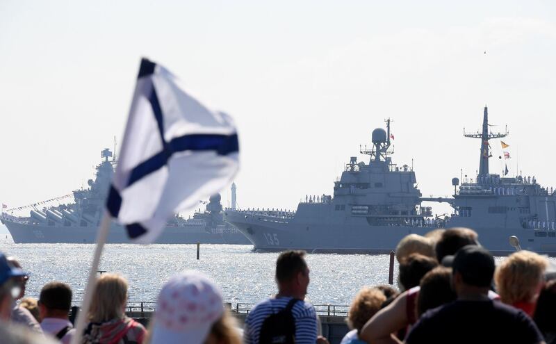 People watch Russian warships sailing in the waters of the Gulf of Finland during the Navy Day parade at Kronshtadt near Saint Petersburg.   AFP / OLGA MALTSEVA