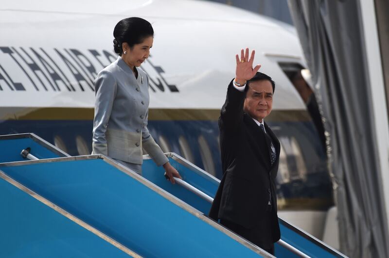 Thailand's prime minister Prayut Chan-O-Cha, right, arrives with his wife Naraporn. Ye Aung Thu / AFP Photo