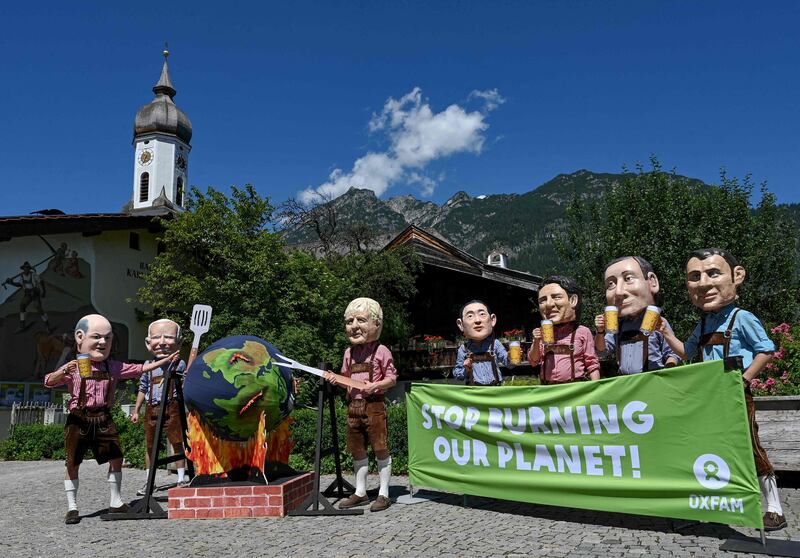 Protesters dressed as the G7 leaders hold up a banner near the summit venue in southern Germany. AFP