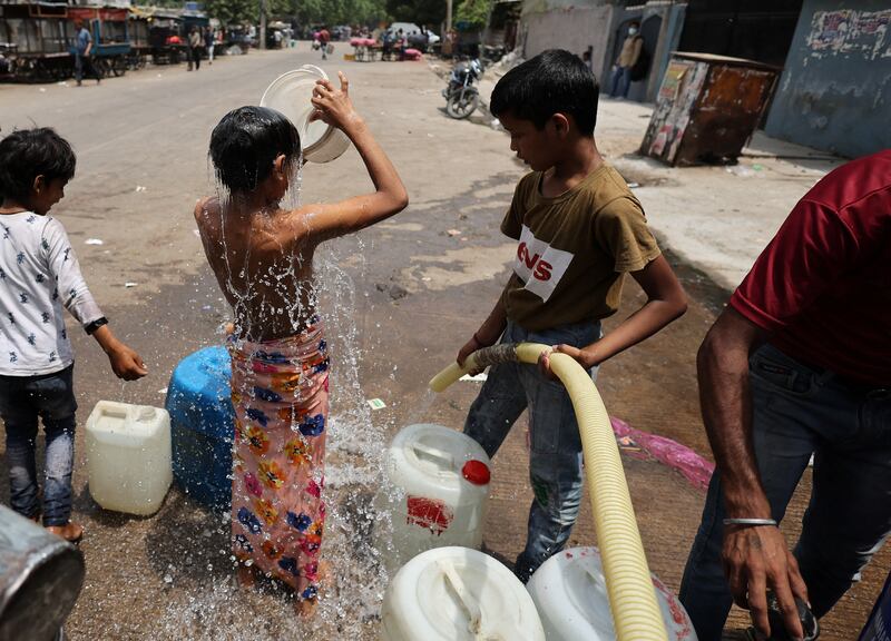A boy bathes as he waits to collect water from a municipal tanker on a hot summer day in New Delhi. Reuters