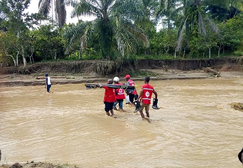 Aid workers crossing flooded areas in Bundibugyo, Uganda. Twitter/UgandaRedCross