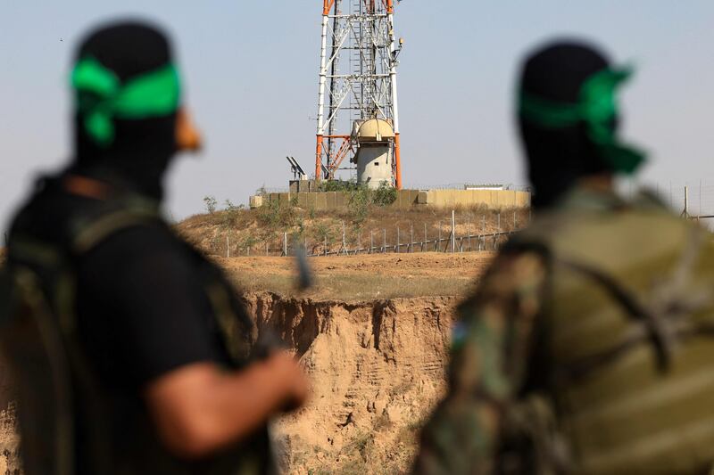 Palestinian fighters of Al Qassam Brigades, the armed wing of the Hamas movement, look towards an Israeli army post near the border in the central Gaza Strip. AFP