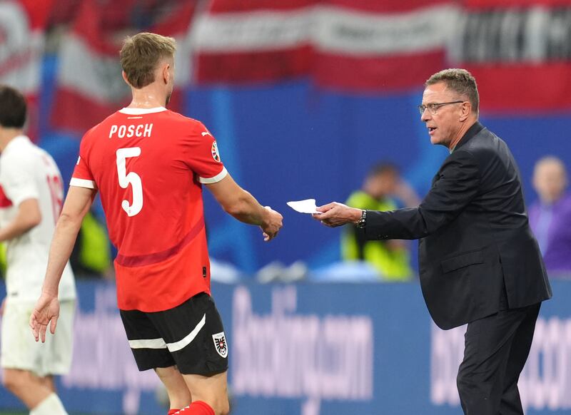 Austria manager Ralf Rangnick passes Stefan Posch a note during the game. PA 