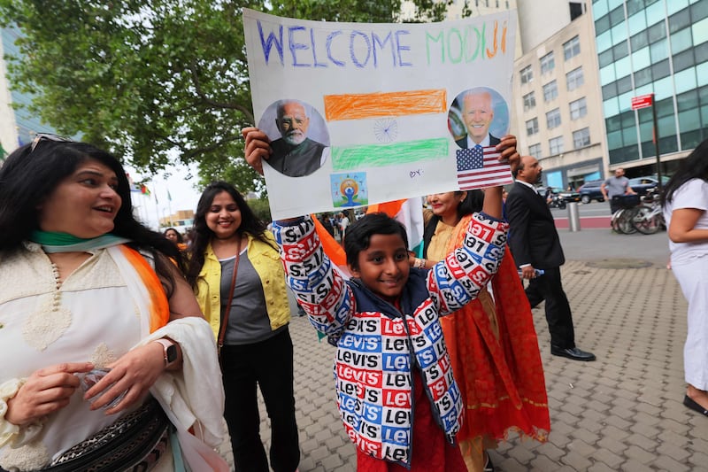 A child raises a homemade poster in front of the UN headquarters in New York to welcome Mr Modi. AFP