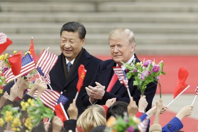 FILE: Bloomberg Best Of U.S. President Donald Trump 2017 - 2020: U.S. President Donald Trump, right, and Xi Jinping, China's president, greet attendees waving American and Chinese national flags during a welcome ceremony outside the Great Hall of the People in Beijing, China, on Thursday, Nov. 9, 2017. Our editors select the best archive images looking back at Trump’s 4 year term from 2017 - 2020. Photographer: Qilai Shen/Bloomberg