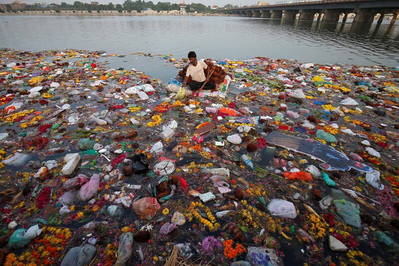 A man collects offerings thrown by worshippers into the Sabarmati river, a day after the immersion of idols of the Hindu god Ganesh in Ahmedabad, India. Amit Dave / Reuters