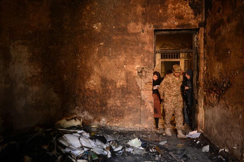 A Pakistani soldier shows the media a burnt classroom at an army-run school on December 17, the day after an attack by Pakistani Taliban militants which left 148 people dead. A Majeed/AFP Photo


