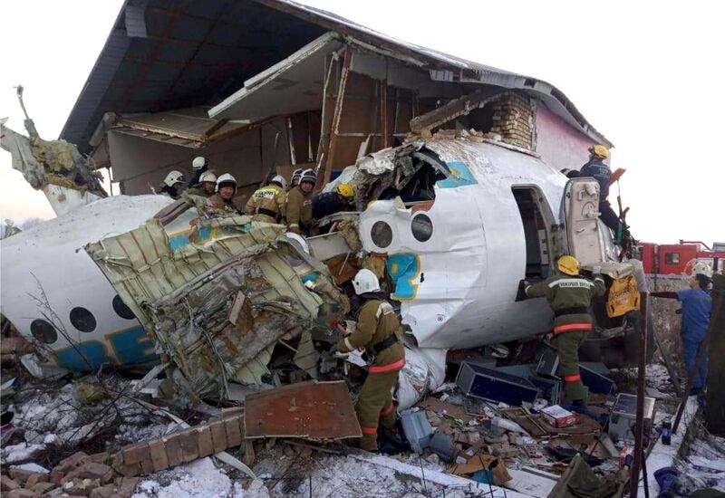 In this handout photo provided by the Emergency Situations Ministry of the Republic of Kazakhstan, police and rescuers work on the side of a plane crash near Almaty International Airport, outside Almaty, Kazakhstan. Almaty International Airport said the Friday crash of a Bek Air plane in Kazakhstan has caused numerous deaths. The aircraft had 100 passengers and crew abroad, and hit a concrete fence and a two-story building shortly after takeoff. AP