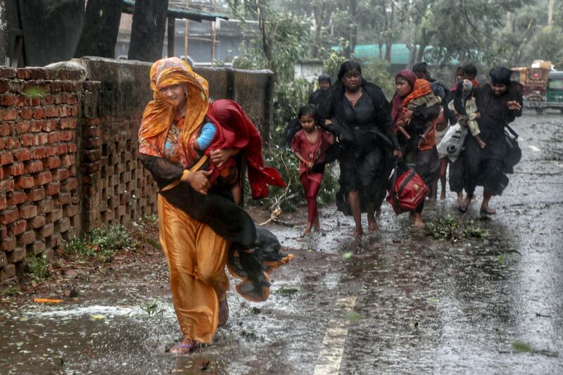People in Shahporir, Bangladesh, hurry to a cyclone shelter after Cyclone Mocha made land in Teknaf. Reuters