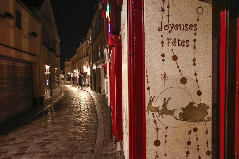 A placard reads  'happy holidays' in an empty street at Montmartre, Paris. AP